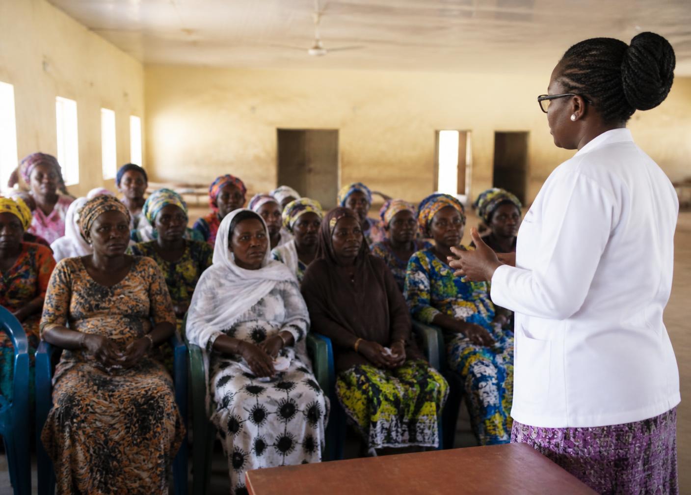 A health educator leading a community cancer awareness session with women in Nigeria